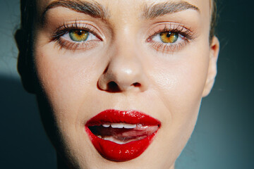 Close-up portrait of a female model with striking green eyes and bold red lipstick, showcasing...