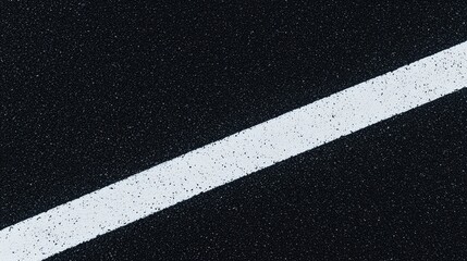 Fototapeta premium A single white line painted diagonally across a dark, textured asphalt road surface.