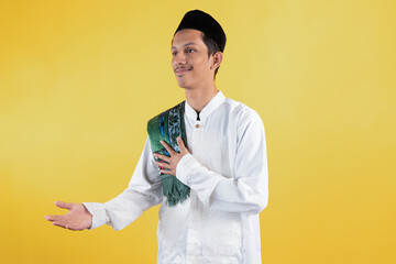 Smiling muslim man wear white shirts with Islamic ornaments and a prayer mat on the shoulder with...