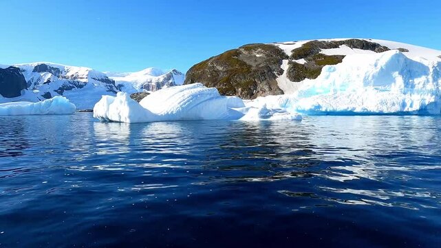 POV at water level from fast moving boat in Orne Harbour amongst drift ice along the Danco Coast west coast of Antarctic Peninsula