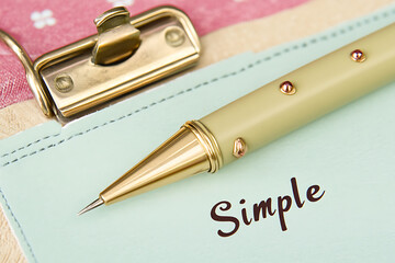 Elegant Pen Resting On Simple Notepad With Gold Accents And Floral Pattern Background Stationery Still Life Composition