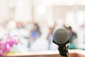 close-up of a microphone with a softly blurred conference room background