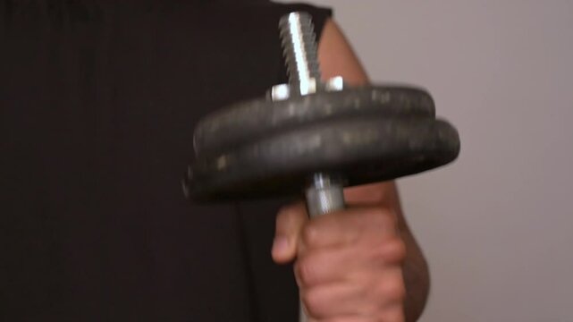 Close-up of a man doing dumbbell curl arm work with supinated arm curl