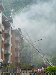 Group of Italian firefighters put out a fire on the roof of an apartment building using ladder trucks