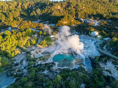 Aerial view of the Te Puia geothermal park in Rotorua, New Zealand. Tourists walk along the boardwalk to view the geysers and hot springs. The park is a popular tourist destination.
