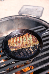 Steak cooking over a campfire