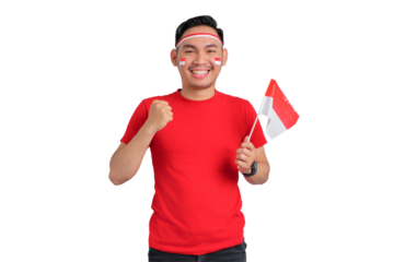 Excited young Asian man celebrating Indonesian independence day holding the Indonesian flag isolated on transparent background