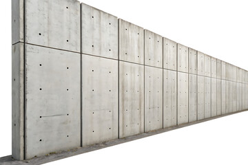 A long concrete wall with square panels and small holes stretching into the distance on a dark day