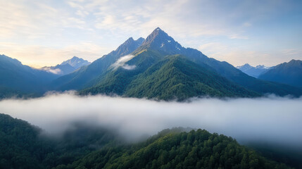 Fototapeta premium Majestic mountain peaks rise above soft morning mist, creating serene landscape