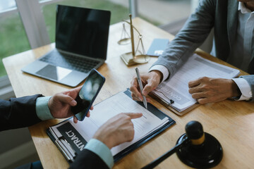 Experienced lawyer reviewing legal documents at office desk, providing professional advice on...