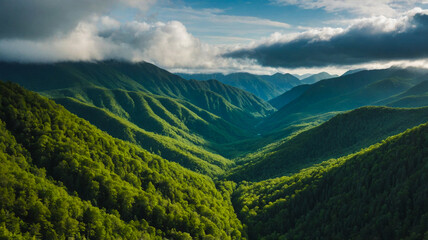 Majestic Green Valley Surrounded by Mountain Ranges and Dramatic Clouds