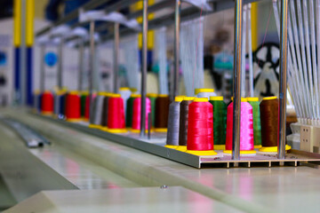 Spools of thread on the conveyor belt in a textile factory