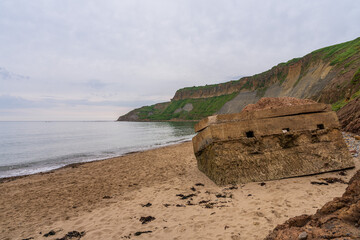 A destroyed World War II bunker on the beach of Cayton Bay, England, UK