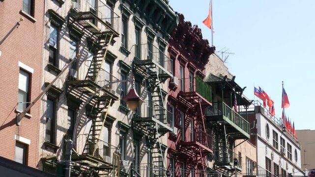 New York City, United States. Manhattan Chinatown Mott street, chinese ethnic district buildings architecture, USA. Flags on chinese community center, little China. Fire escape ladder. Attached houses