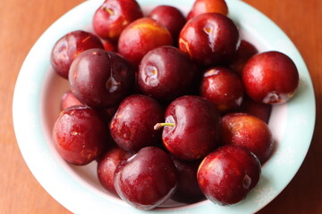 Ripe plum, fresh red plum fruits in a bowl