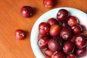 Ripe plum, fresh red plum fruits in a bowl