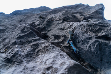 A hook with a loop driven into a crack in the rock on a climbing route to belay the person climbing.