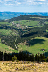 Top view of the town located in a valley between hills with forests and meadows.
