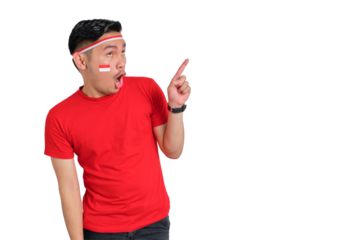 Shocked young Asian man celebrating Indonesian independence day pointing aside at copy space isolated on transparent background