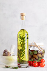 Olive oil with rosemary and garlic on a white background.