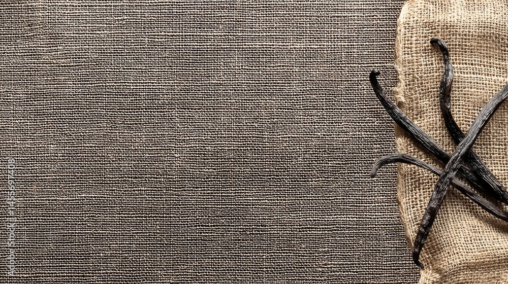 Poster Vanilla pods are arranged loosely on a rough burlap surface, emphasizing their natural brown hues and providing space for additional text or graphics