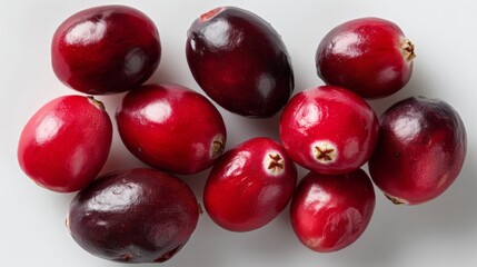 Fresh cranberries display their bright red hue against a clean white surface, perfect for highlighting their natural appeal in recipes or festive d&eacute;cor