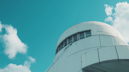 Modern Architectural Design Showcases Smooth Curves and Reflective Surfaces Against a Clear Blue Sky in an Urban Setting During the Afternoon