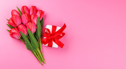 Pink tulip bouquet and gift box on a soft pink background