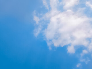 Clear Blue Sky with Soft White Clouds on a Sunny Day. Bright blue sky with gentle white clouds scattered across a sunny backdrop
