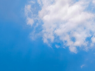 Clear Blue Sky with Soft White Clouds on a Sunny Day. Bright blue sky with gentle white clouds scattered across a sunny backdrop
