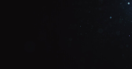 natural dust particles flow in air on black background