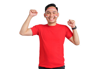 Fototapeta premium Excited young Asian man celebrating Indonesian independence day standing while raising fist isolated on transparent background