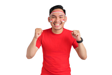 Fototapeta premium Excited young Asian man celebrating Indonesian independence day standing while raising fist isolated on transparent background