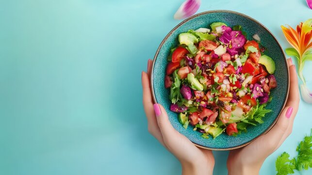 Womans hands holding colorful salad bowl over blank surface, healthy lifestyle concept, ready for text or inscriptions