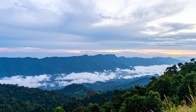 breathtaking panorama of foggy mountains at sunset, showcasing lush greenery and rolling hills beneath dramatic sky. serene landscape evokes sense of peace and wonder