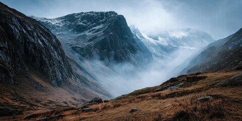 Misty Cliffside Mountain Rising Above Golden Grass Hillside in Autumn Light, Dramatic Landscape with Steep Rocky Slopes, Rugged Nature Scene Evoking Solitude, Wilderness, and Majestic Elevation