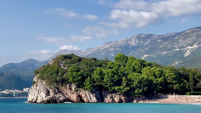 Grota skalna sea cave landmark in Montenegro with pine trees, rocky coast and Adriatic mountain backdrop