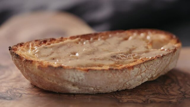 Slow motion man hand taker ciabatta slice with hazelnut spread closeup