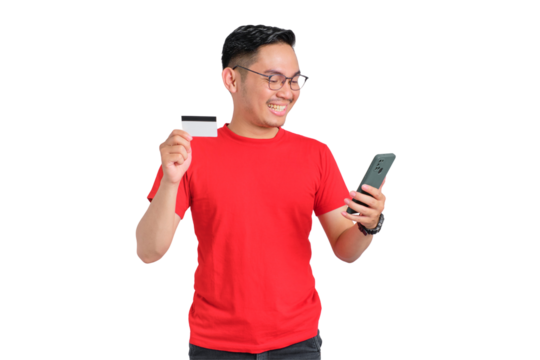 Cheerful young Asian man holding mobile phone and credit card isolated on transparent background