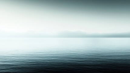 A serene body of water with a hazy sky and distant mountains.