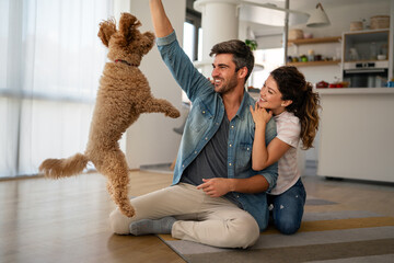 Cute dog enjoys love from owners at home. Couple pets and cares for furry friend, creating a bond.