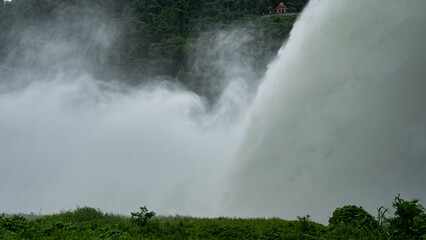 Water flowing over big floodgates of a dam