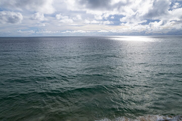 Fototapeta premium Aerial view of a blue sea surface water texture background and sun reflections Aerial flying drone view Waves water surface texture on sunny tropical ocean in Phuket island Thailand