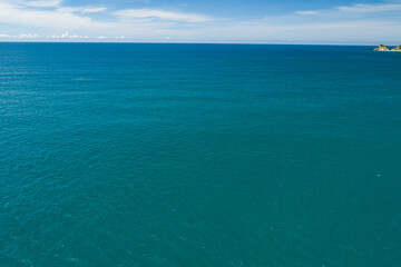 Obraz premium Aerial view of a blue sea surface water texture background and sun reflections Aerial flying drone view Waves water surface texture on sunny tropical ocean in Phuket island Thailand