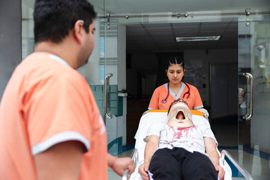 Nurses transporting a patient on a stretcher at a hospital entrance