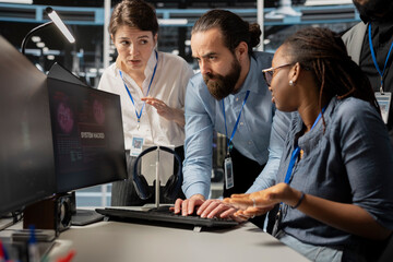 Worried computer scientists in data center reacting to virus alert, initiating protocol to protect...