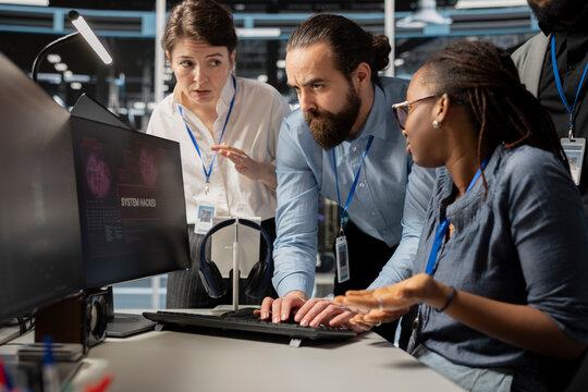 Worried computer scientists in data center reacting to virus alert, initiating protocol to protect systems. Server room staff members cooperating, assessing compromised gear after hacker attack - Powered by Adobe