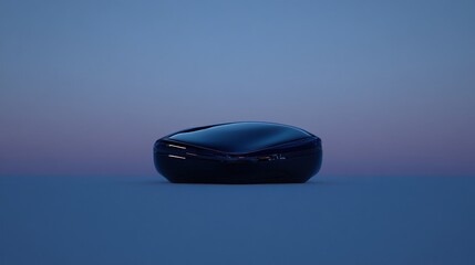 Sleek, dark, futuristic portable device rests on a muted background.  A smooth, sculpted form with hidden details