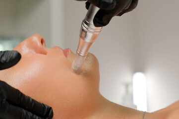 Microneedle RF lifting procedure. A cosmetologist performs a facial rejuvenation procedure on a...