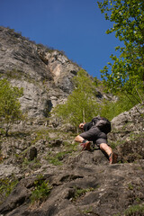 Obraz premium Man climbing rocky slope